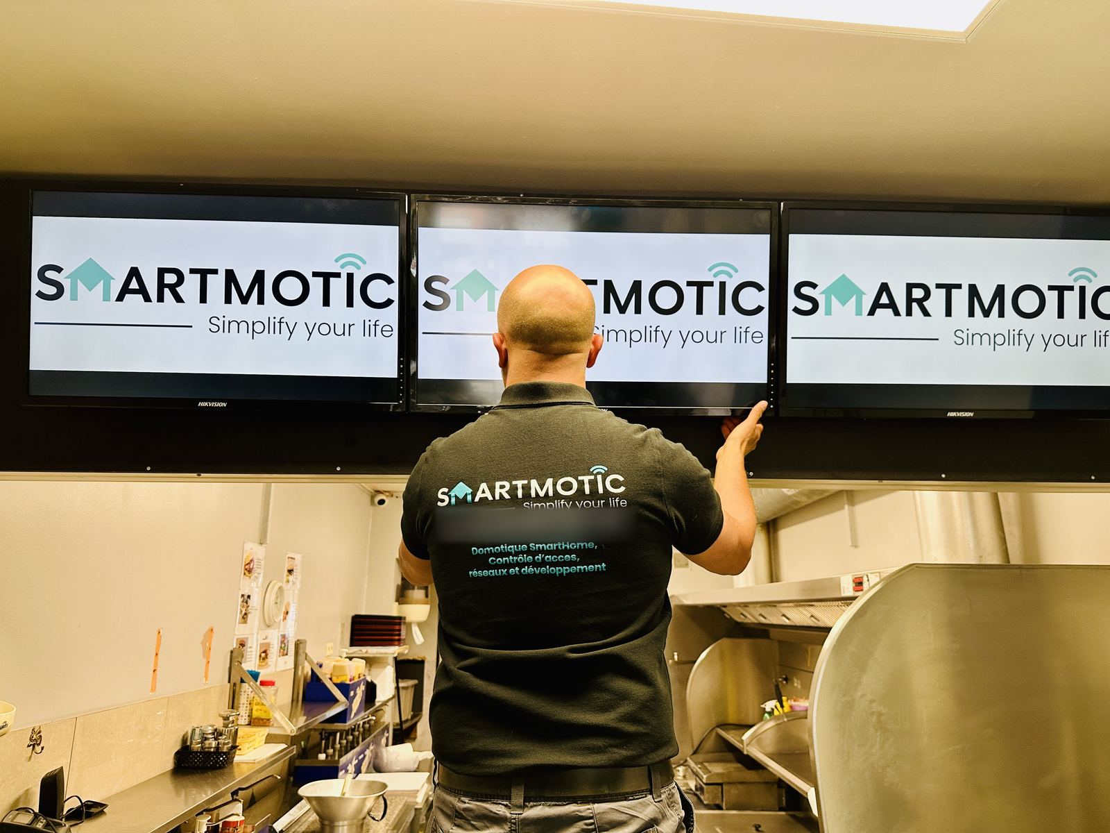 Trois écrans d'affichage dynamique installés dans un commerce